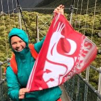 Udall 2018 recipient Emma R. Johnson holding up a cougar flag while studying abroad in New Zealand.